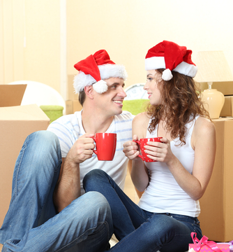 Young couple with boxes in new home celebrating New Years